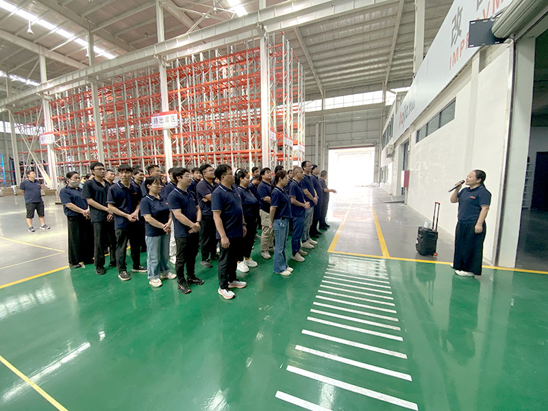 AOJIA employees gather on the factory floor to listen to a speaker at an innovation briefing.
